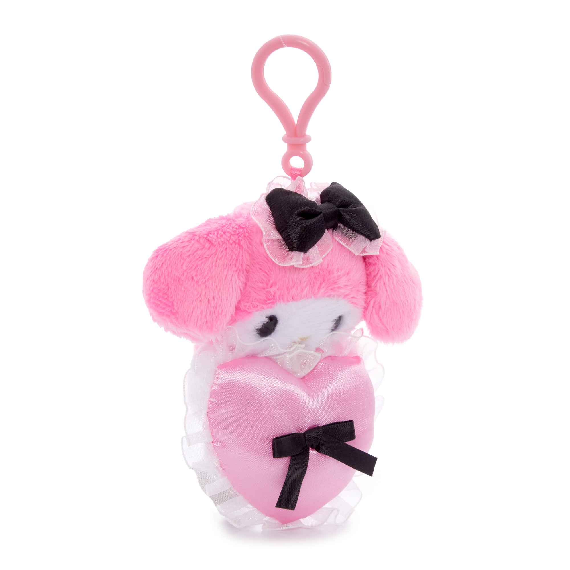 My Melody plush clip sitting on a wooden desk beside stationery