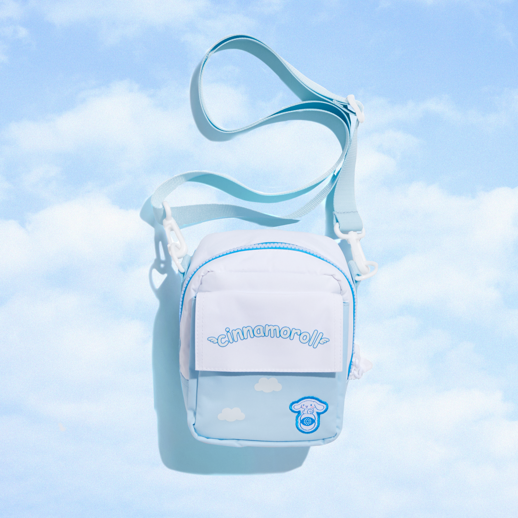 Front view of Cinnamoroll camera bag showing zippered compartments and logo