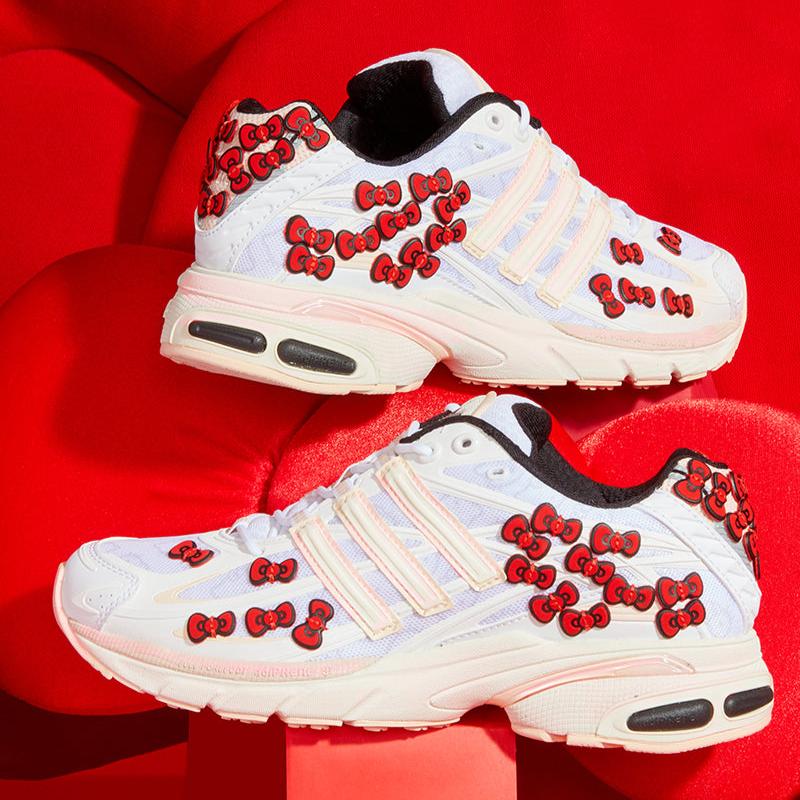 Side view of Hello Kitty adidas sneakers with red ribbons and white leather accents