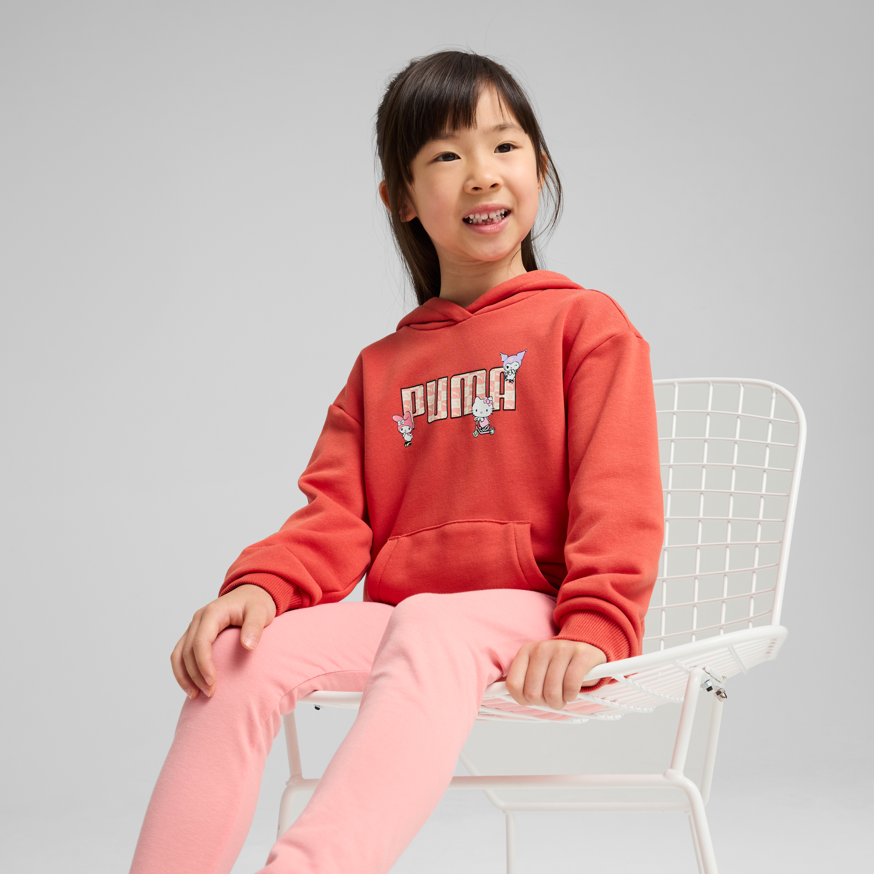 Front view of the Hello Kitty and Friends x PUMA kids hoodie in vibrant red with playful graphics
