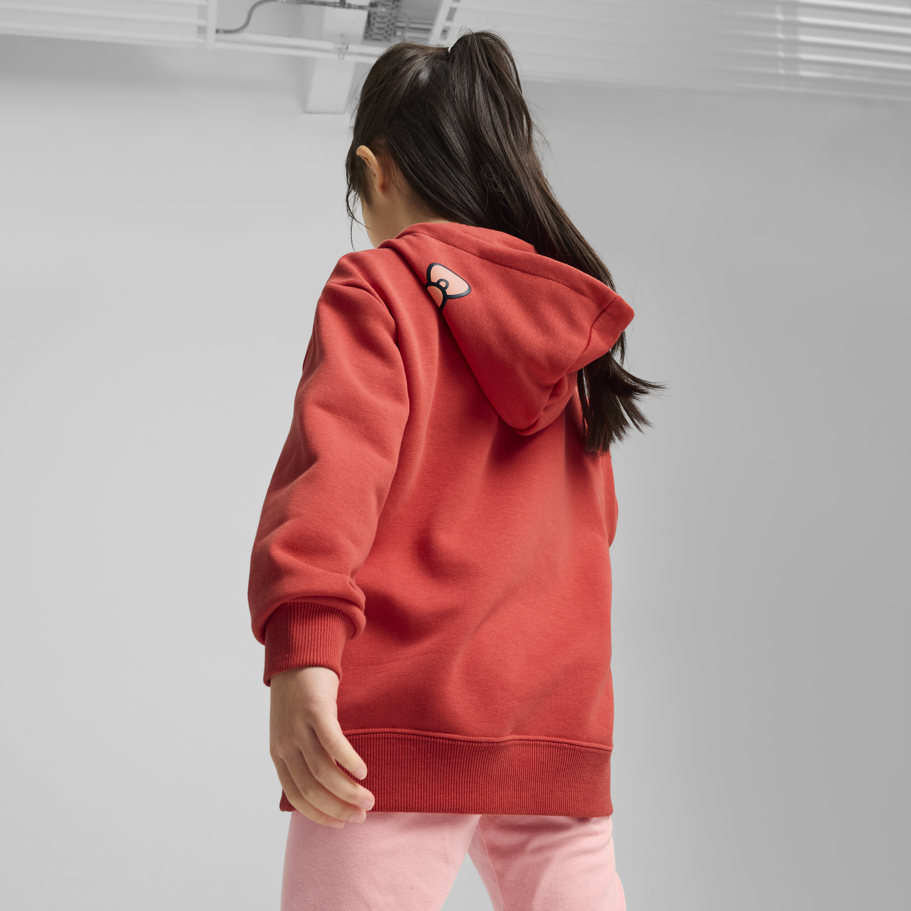 Child playing outdoors wearing the lightweight Hello Kitty hoodie with a cozy front pouch pocket