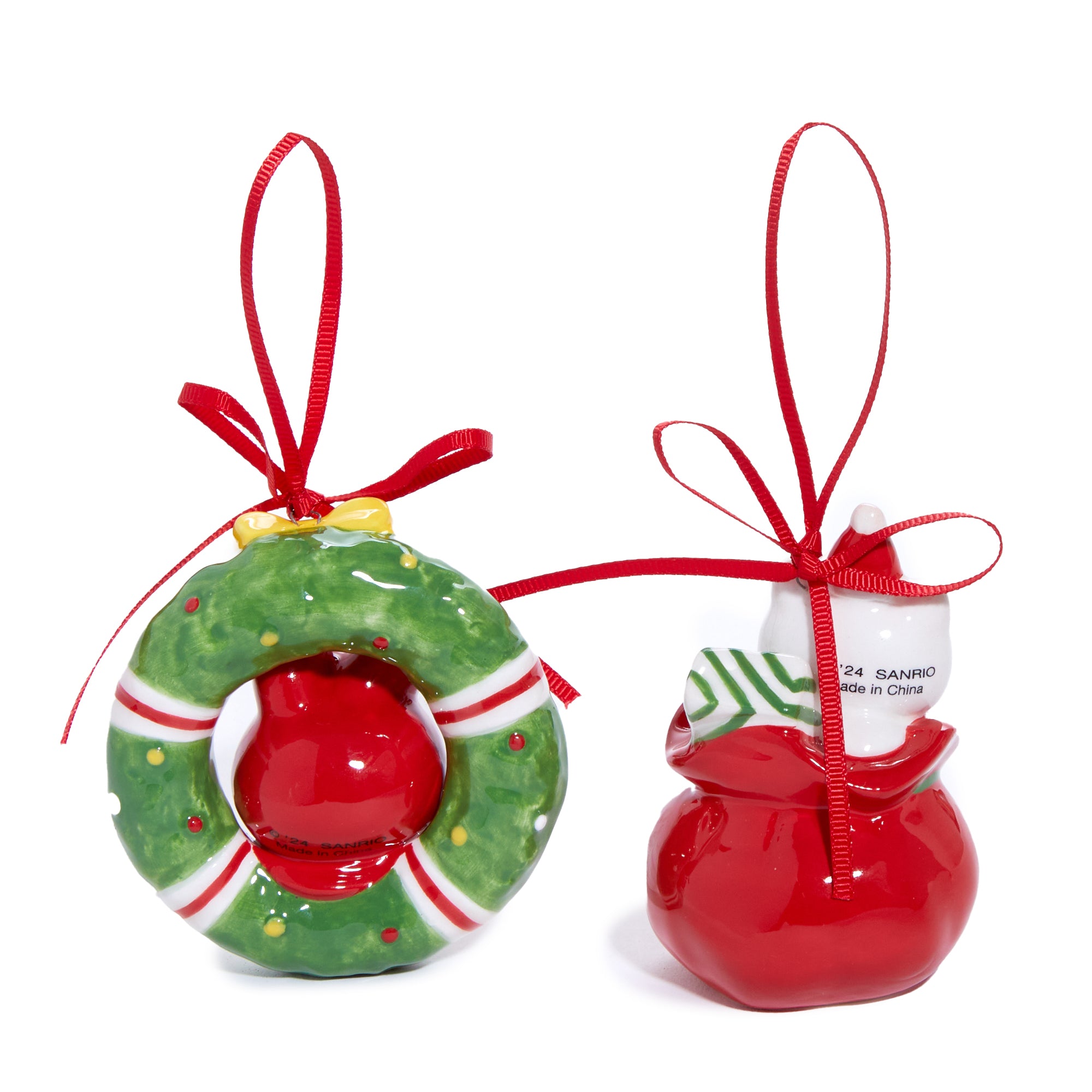 Front view of Hello Kitty ornament in red holiday outfit, hanging from a pine tree.