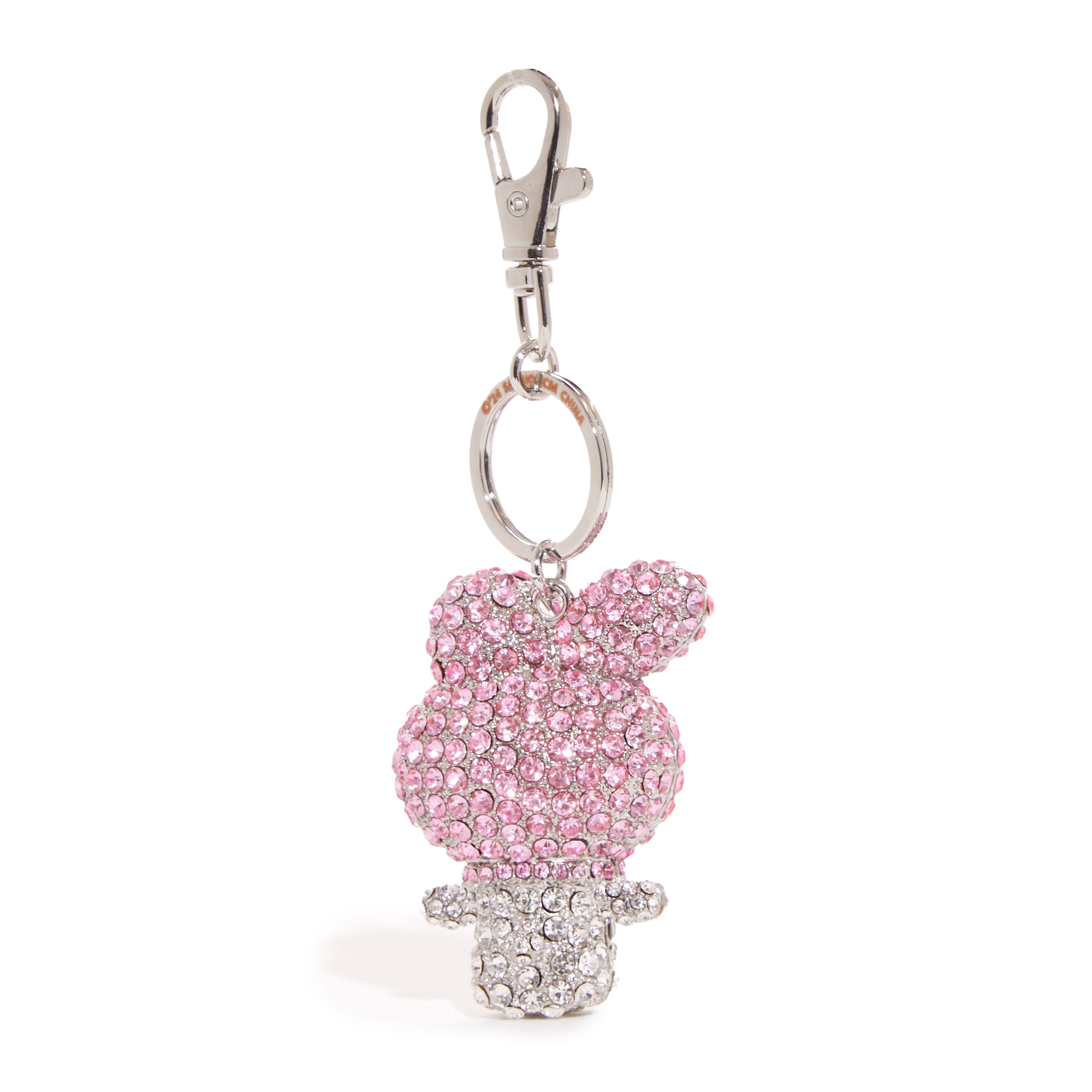 Stylish flat lay of the keychain next to a pink backpack for size reference.
