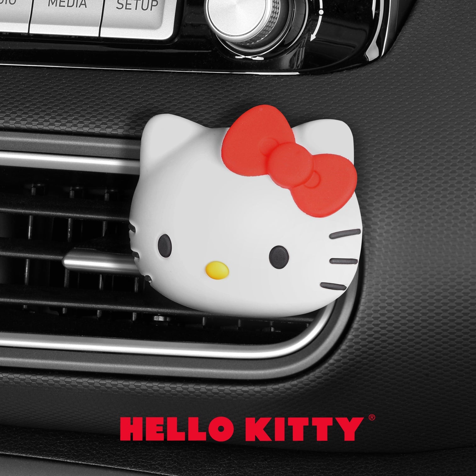 Hello Kitty car air freshener with tropical scent clipped to a car vent