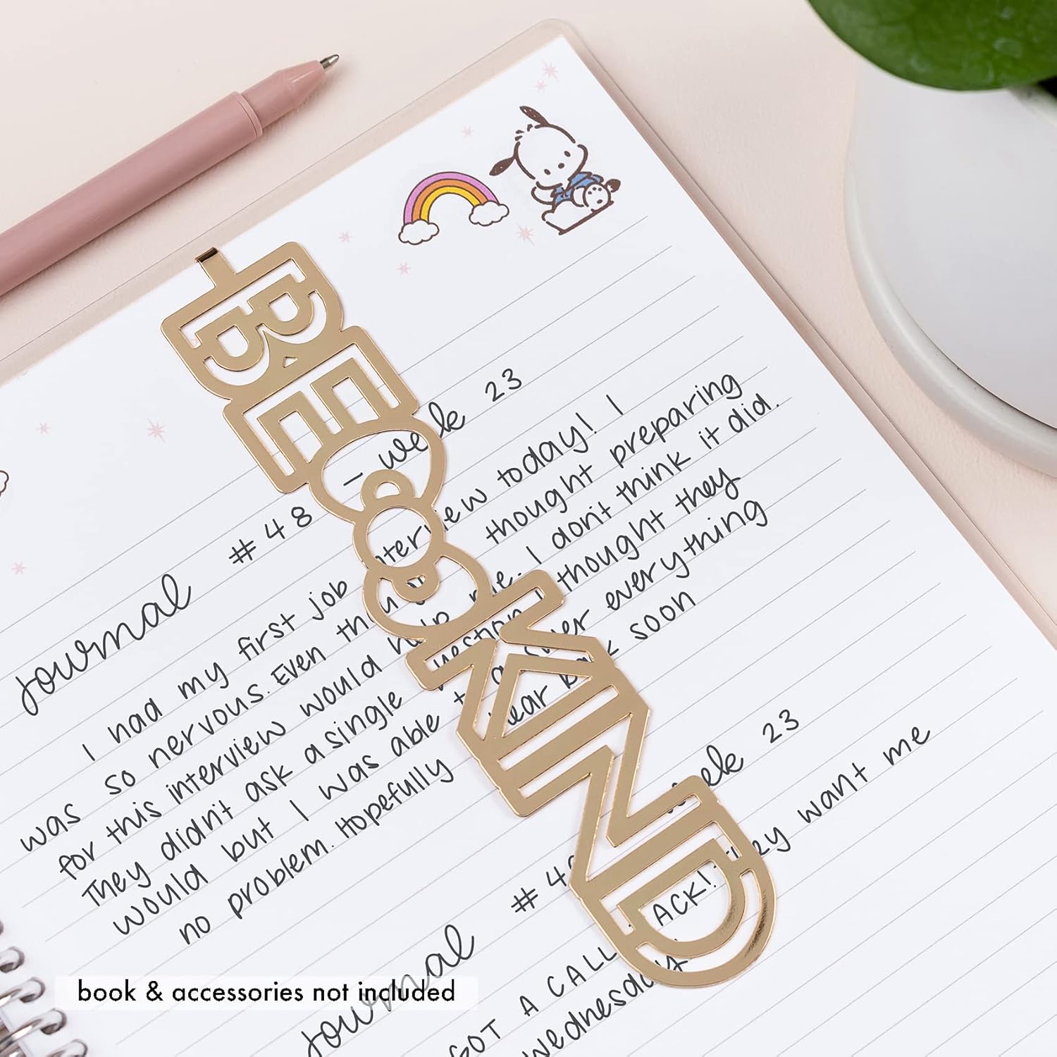 Close-up of gold metal bookmark with Hello Kitty bow clipped to a journal