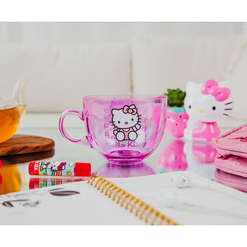 Side view of the pink glass mug showing dual Hello Kitty graphics in soft morning light.