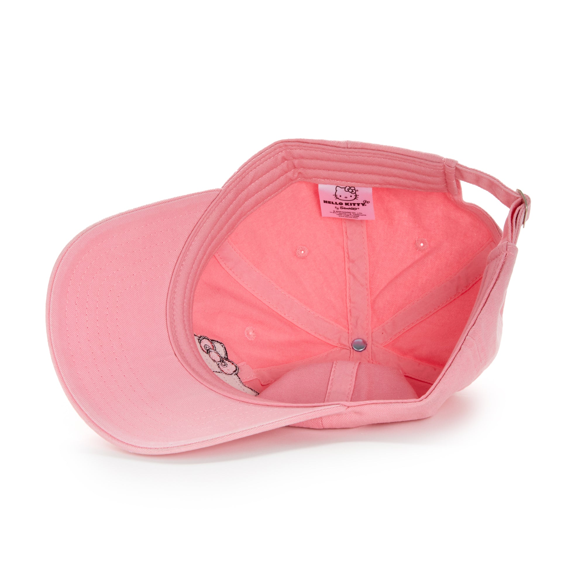 Street-style shot of woman wearing hot pink baseball hat with Hello Kitty embroidery in urban NYC setting