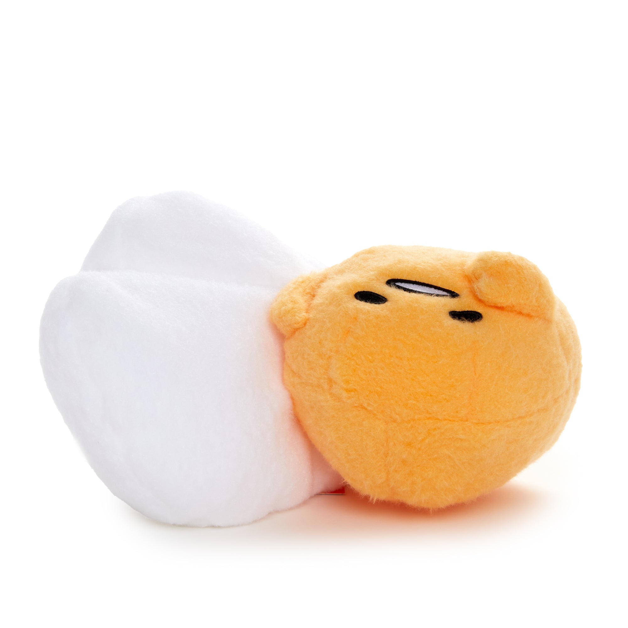 Gudetama cuddle plush doll sitting on a desk, ideal for napping or as a gift.