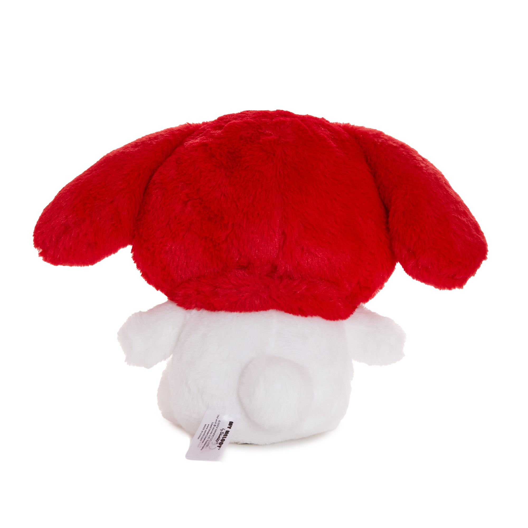 My Melody plush toy displayed on a cozy bed, showcasing its red hood and fluffy texture.