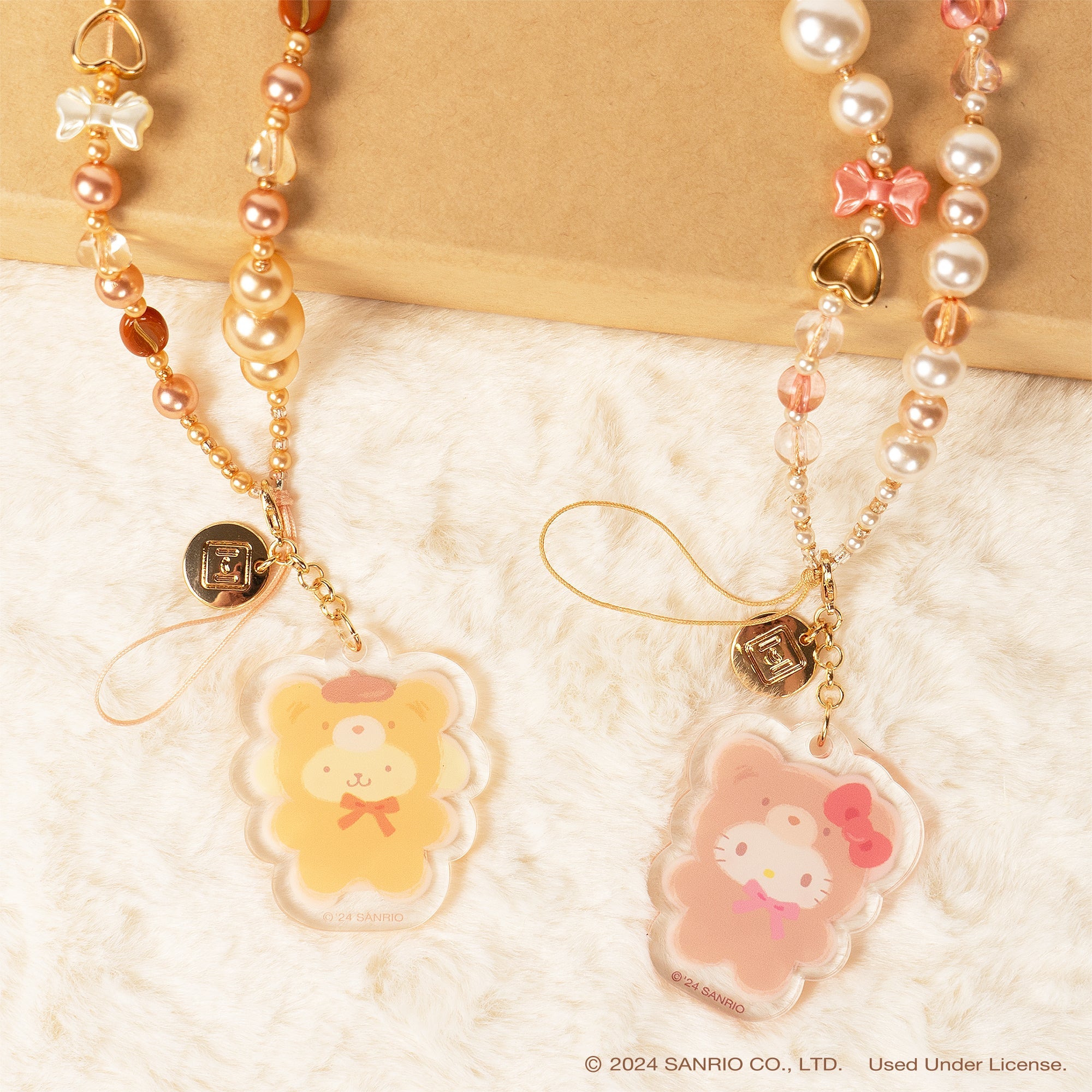 Person using the Hello Kitty phone strap while shopping outdoors.