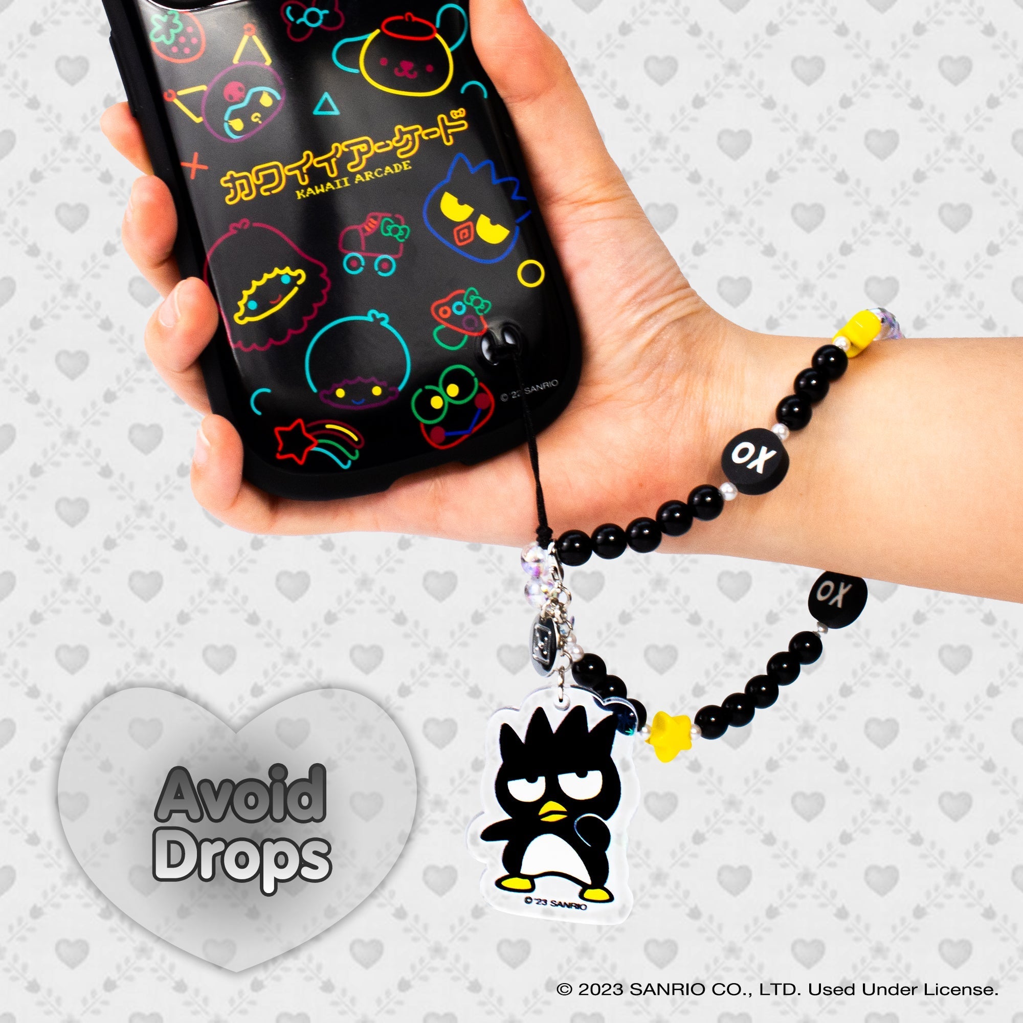 Close-up of glitter Badtz-maru phone charm on wrist strap cell phone case