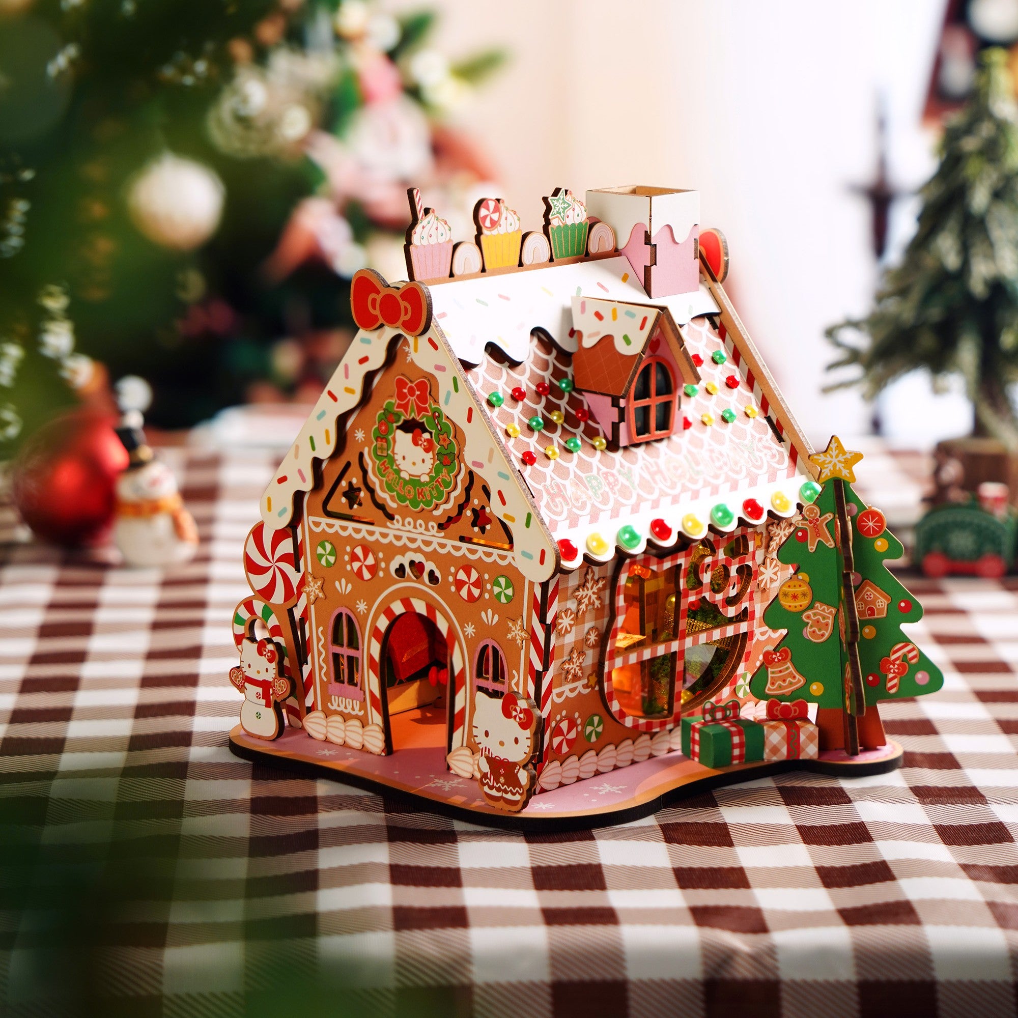 Kids and adults assembling the wooden gingerbread house kit together