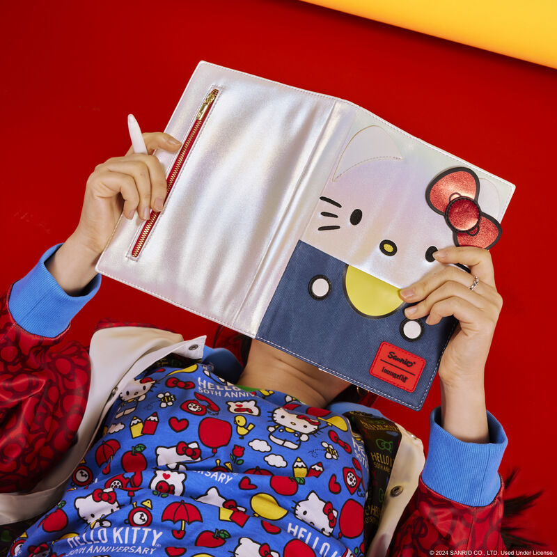 Hello Kitty journal lying open on a desk with a pen and sticky notes nearby