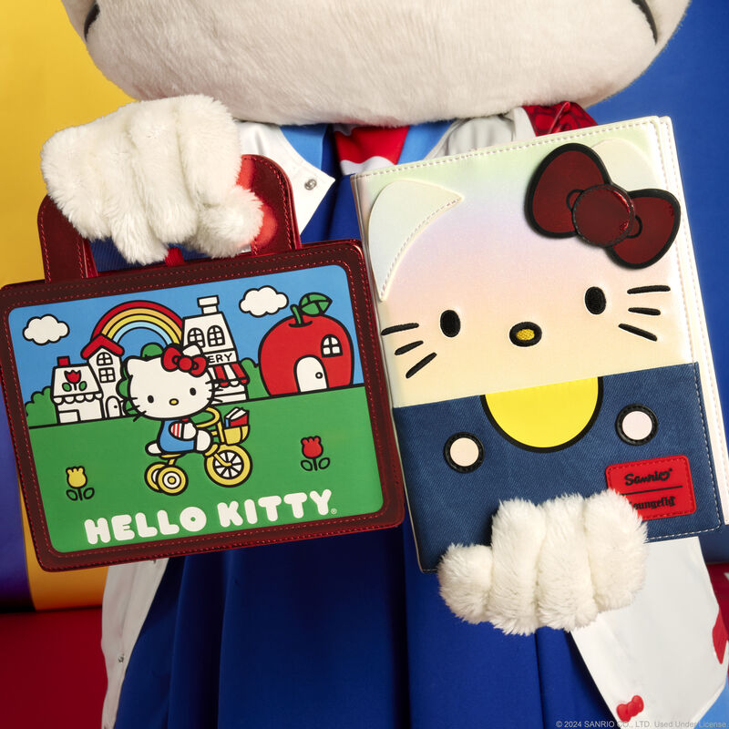 Hello Kitty journal lying open on a desk with a pen and sticky notes nearby