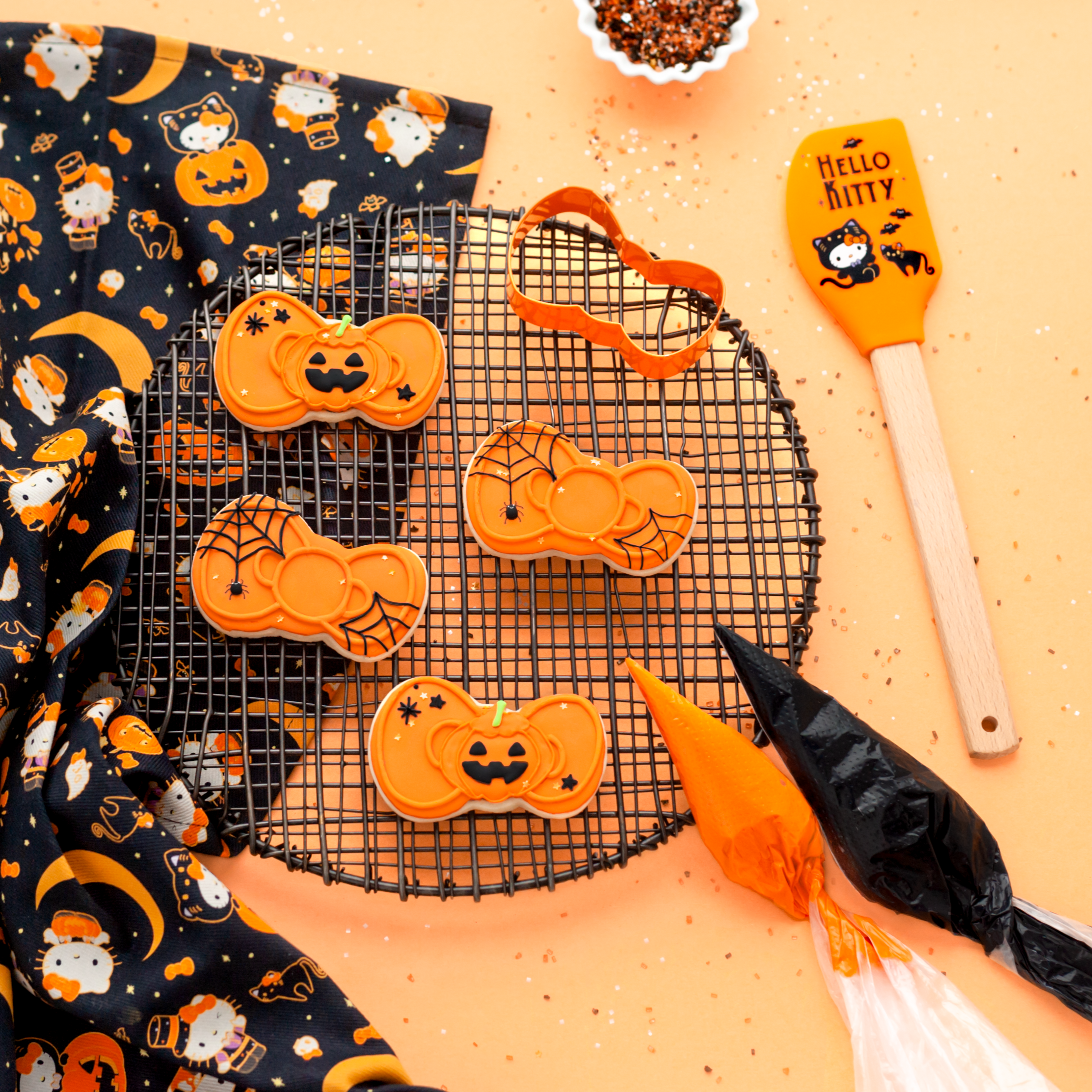 Silicone spatula with colorful print beside freshly cut cookie shapes