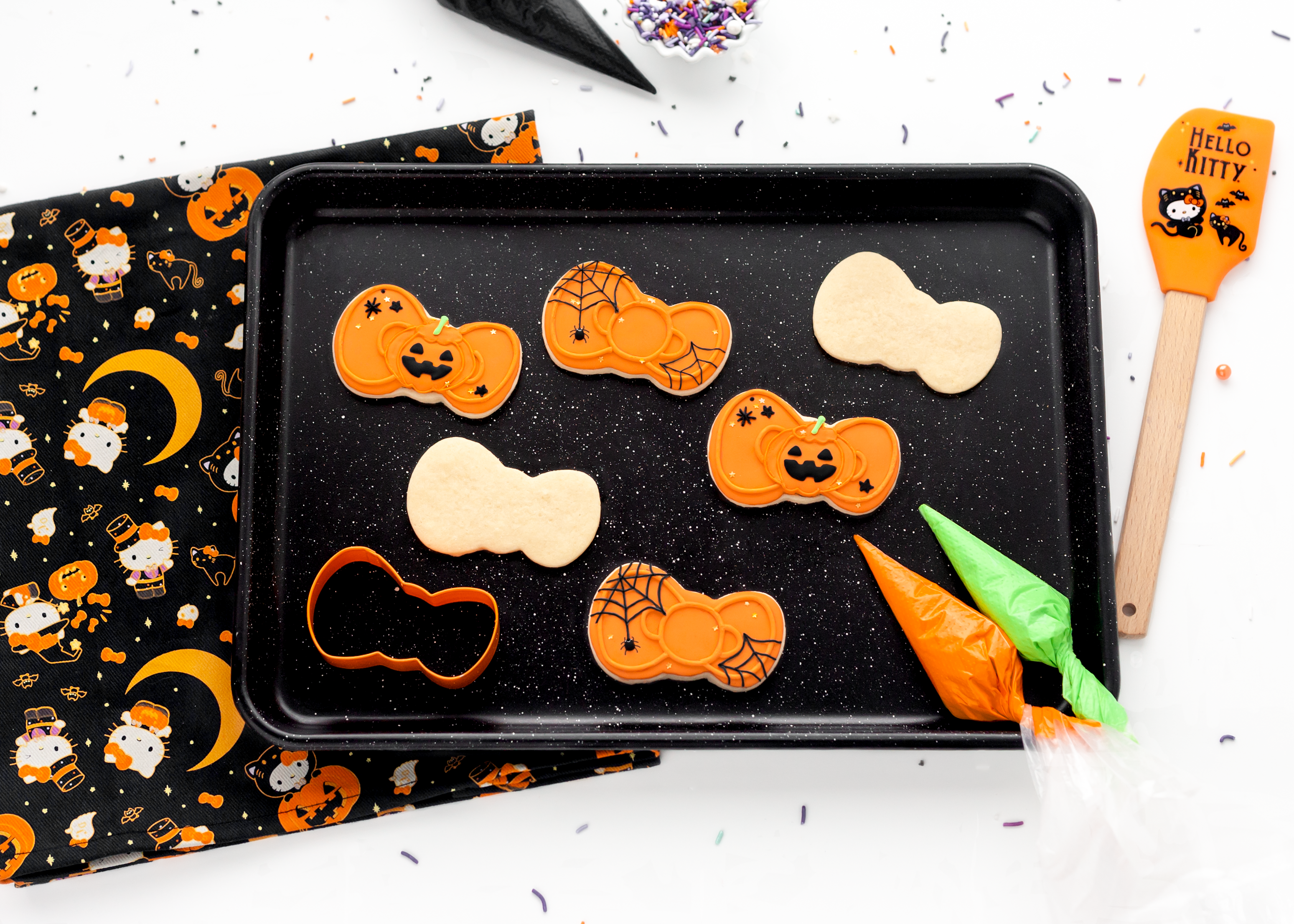 Close-up of Hello Kitty cookie cutter pressing into dough for Halloween cookies