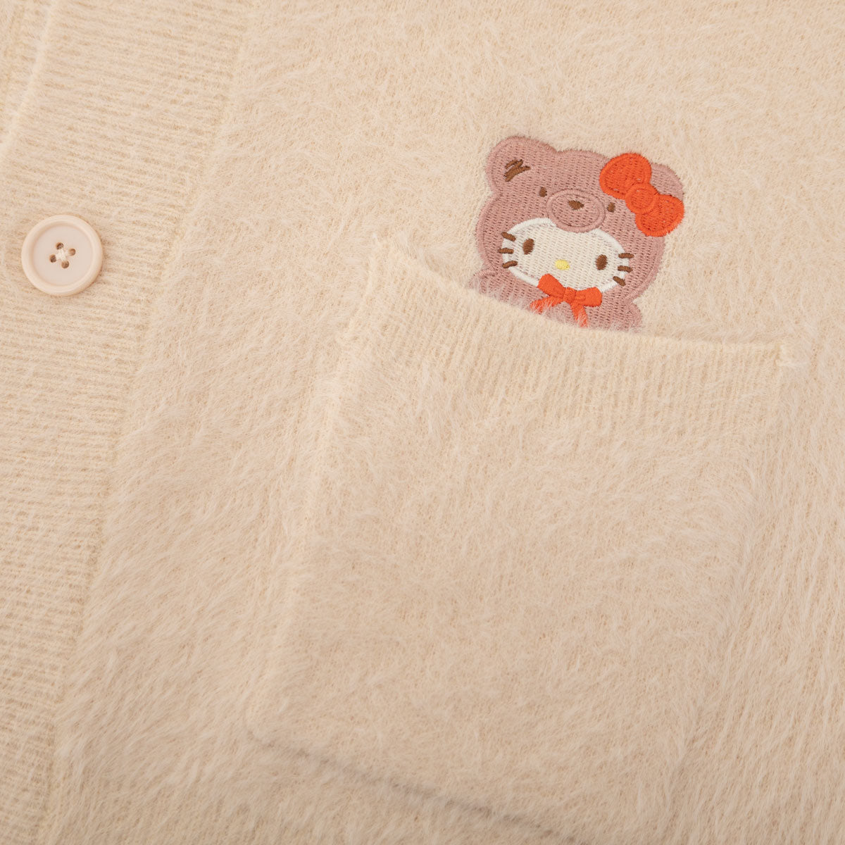 Close-up of the Hello Kitty design on the cardigan, featuring the character in a bear outfit