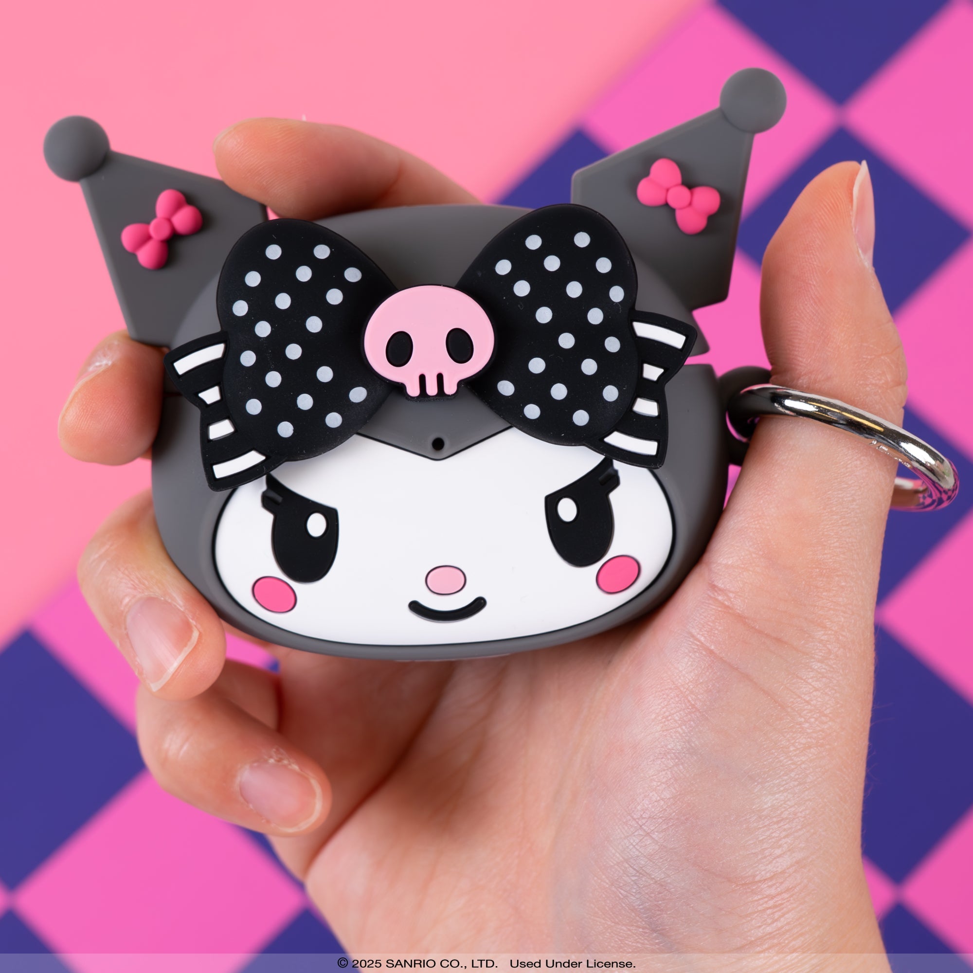 Kuromi AirPods case attached to a backpack using the carabiner clip