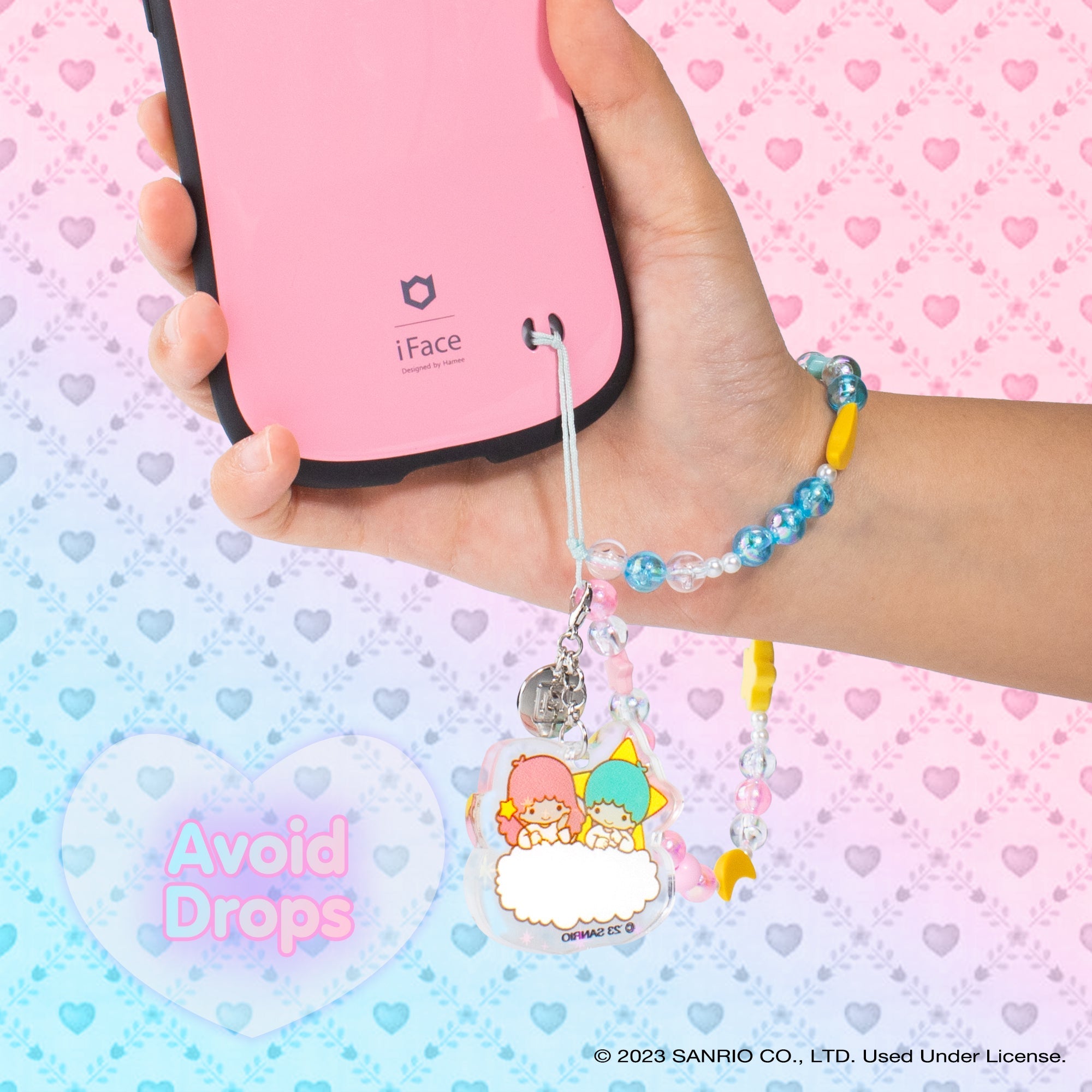 Little Twin Stars phone charm on a colorful wrist strap.