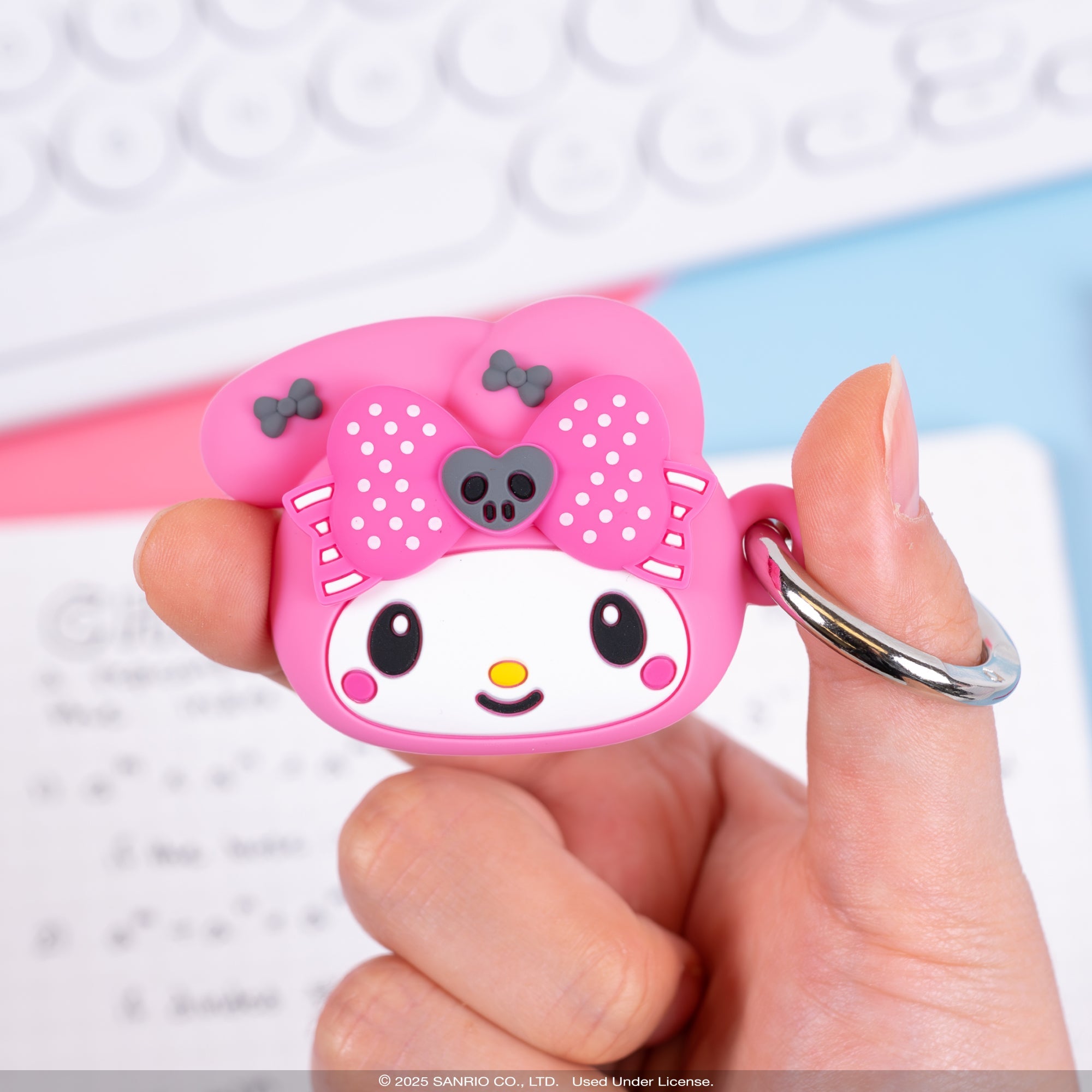 My Melody AirTag case hanging from a backpack