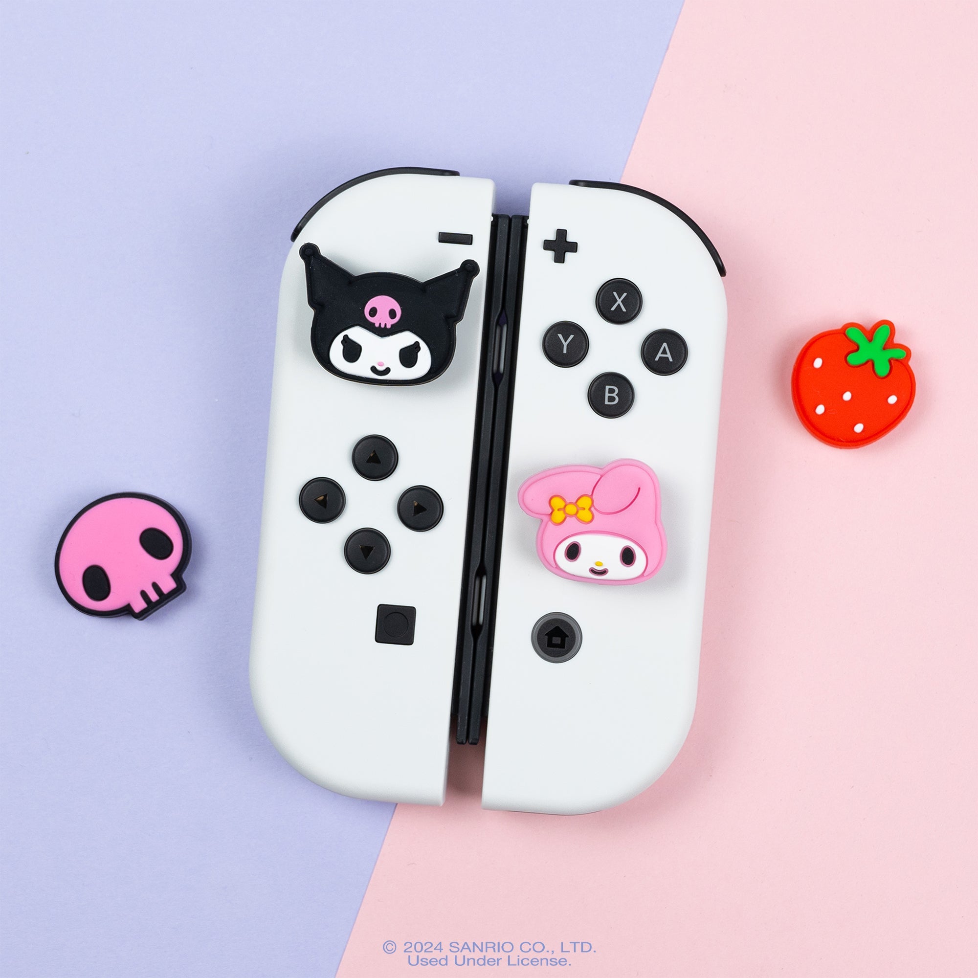 Close-up of strawberry design grip cap next to Switch Lite