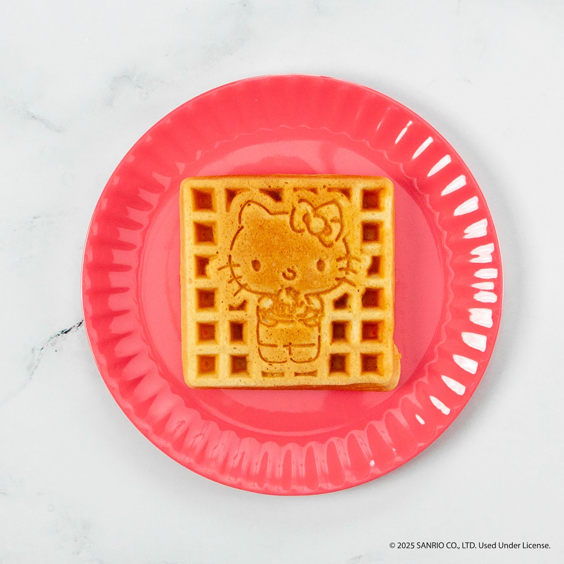 Waffles cooking in the non-stick plates of the Hello Kitty waffle maker