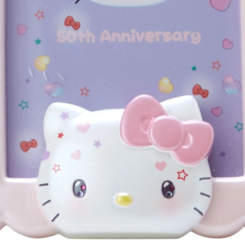Hello Kitty 50th anniversary photo frame displayed on a shelf with plush toys