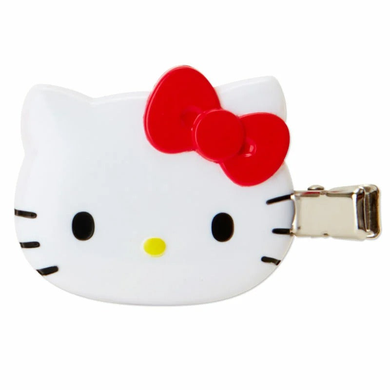 Two red Hello Kitty mini hair clips placed on a colorful outfit, highlighting their fashion accessory potential