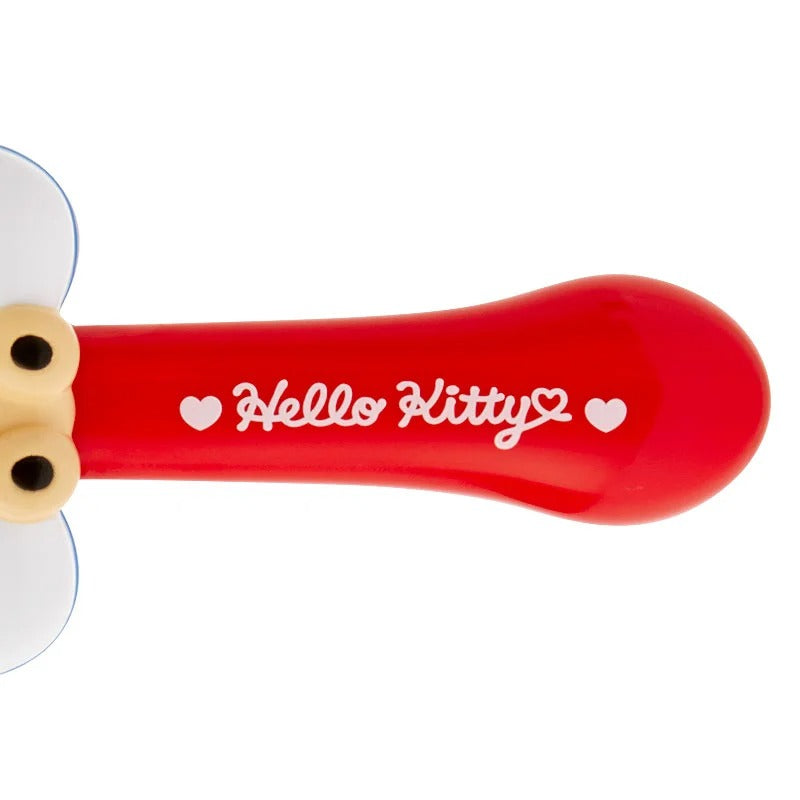 Compact Hello Kitty brush tucked into a makeup bag for travel convenience
