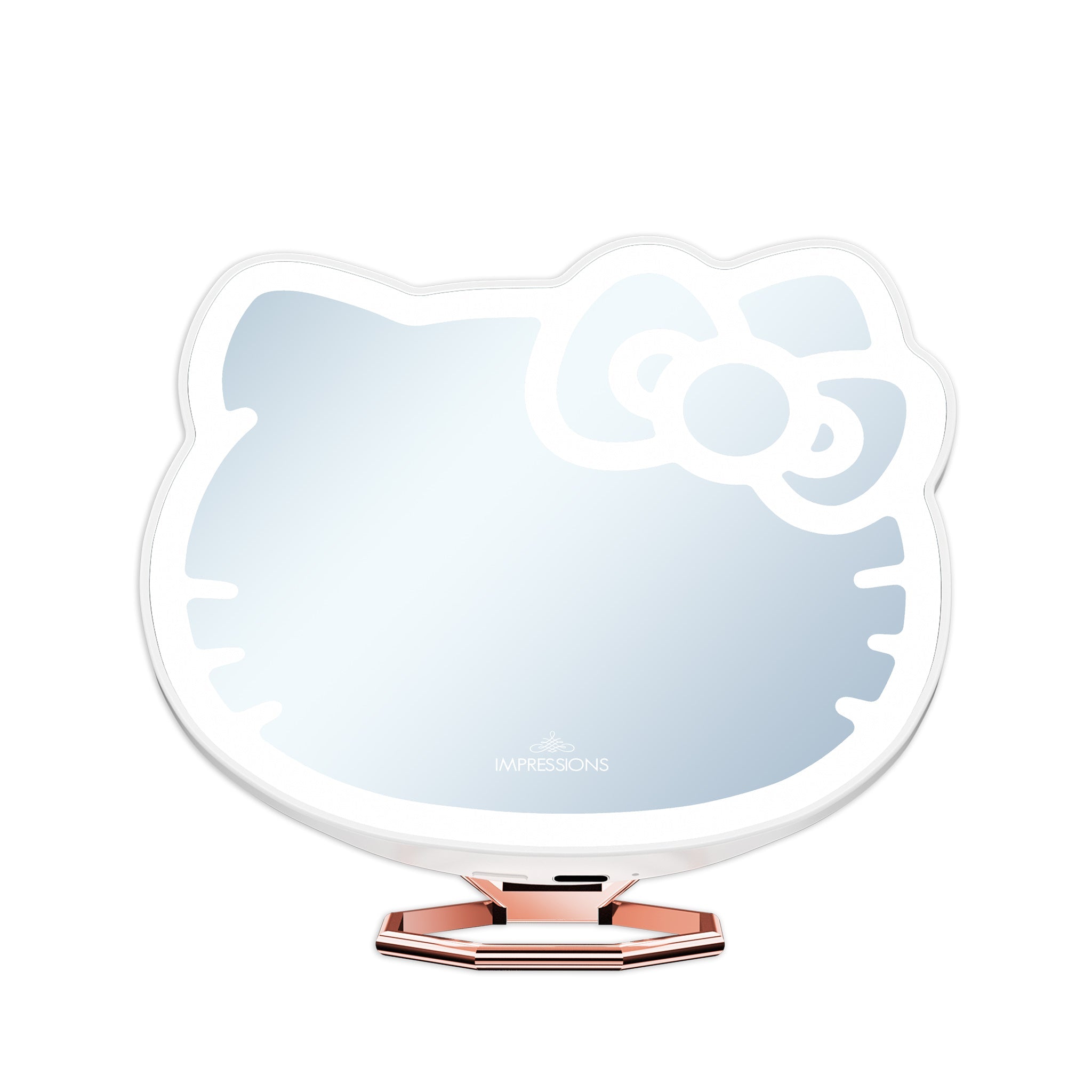 Hello Kitty compact mirror propped up on a vanity table with makeup