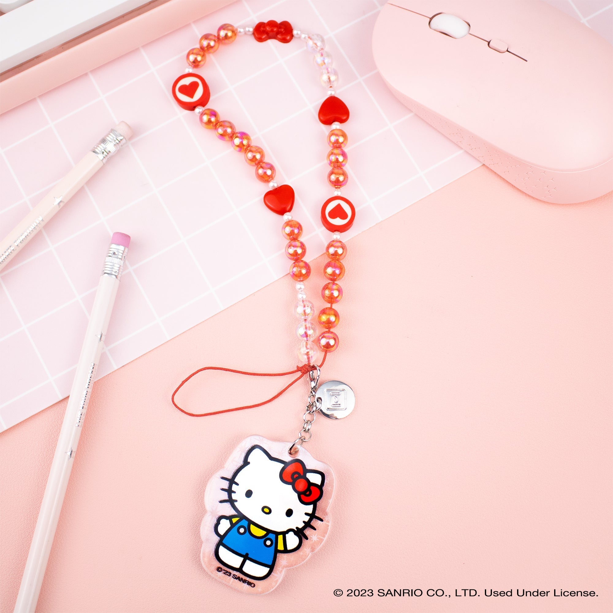 Close-up of the detachable iridescent glitter Hello Kitty charm attached to the beaded strap.