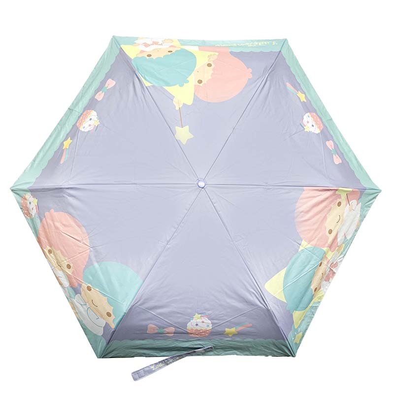 Sanrio travel umbrella folded neatly beside a purse, highlighting portability.