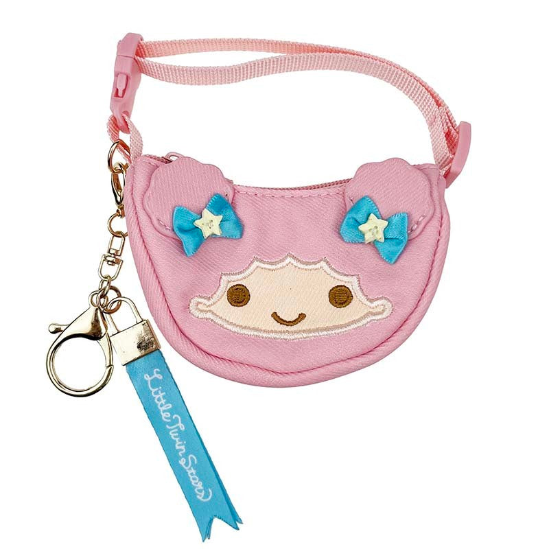 Front angle of mini crescent bag hanging as a charm on a neutral leather tote