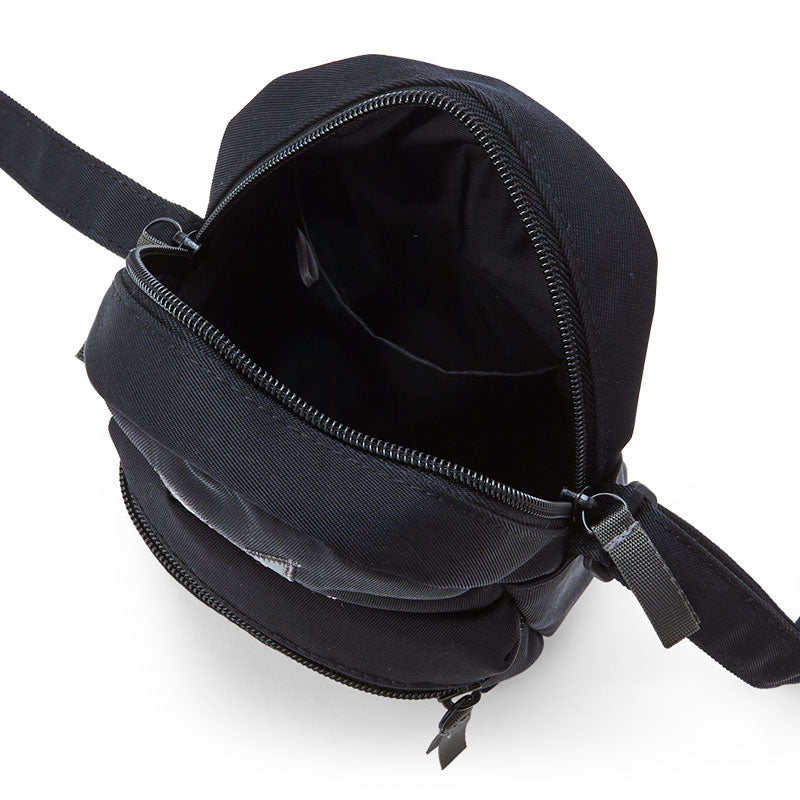Close-up of the leather crossbody bags zippered pockets and adjustable strap
