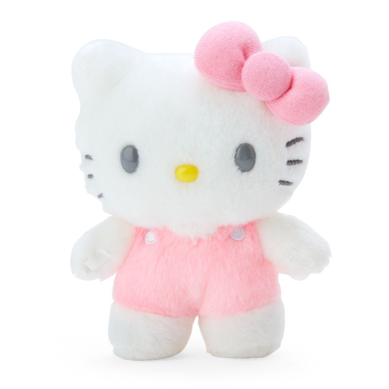 Standing Hello Kitty plush doll in a graduation outfit, posed on a desk with a cute expression