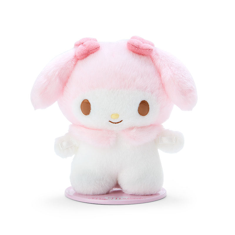 My Melody plush with magnetic feet on a colorful bookshelf.
