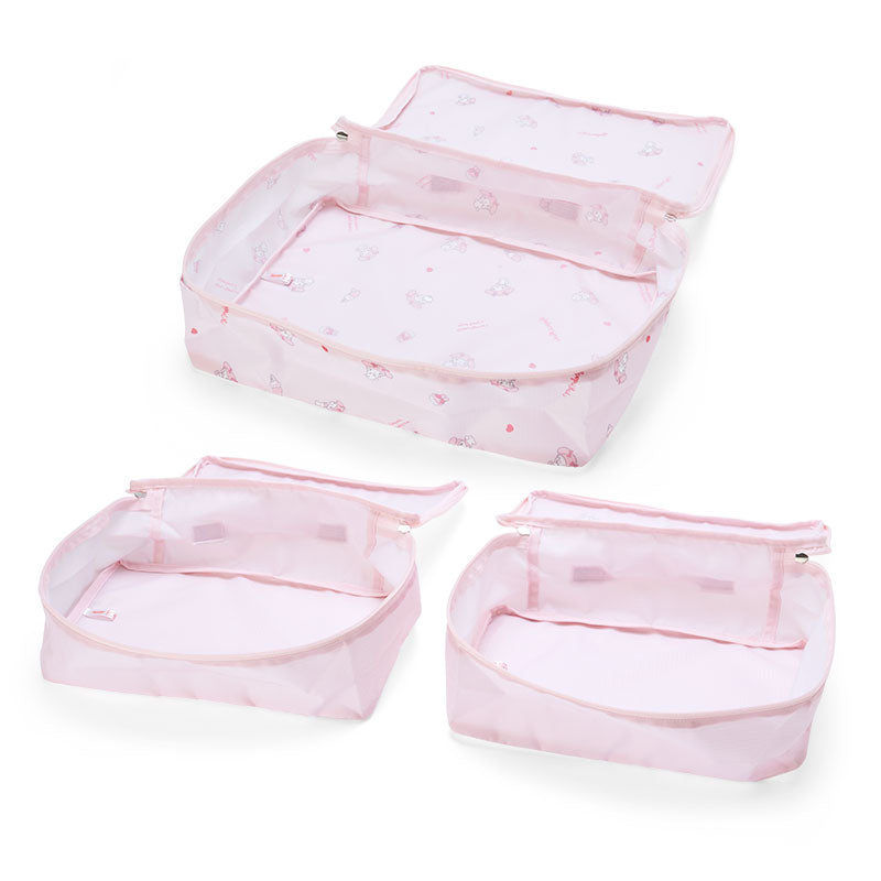 Travel organizer set with top handle and double heart zippers on a hotel bed