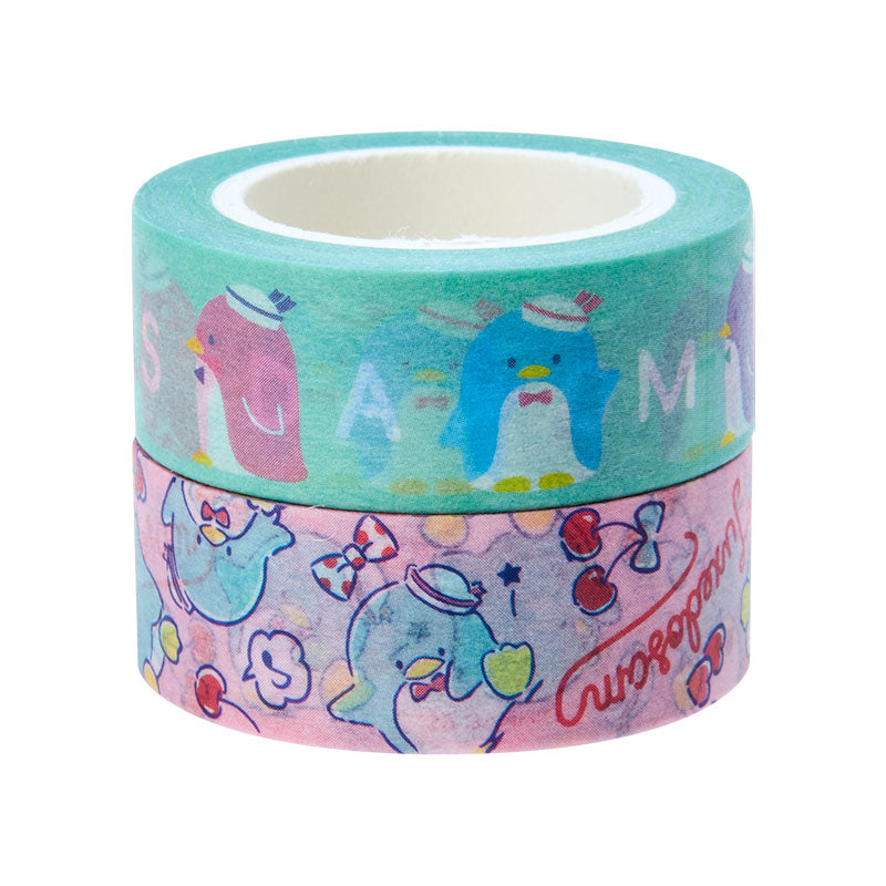 Hand holding Tuxedosam tape while decorating a journal page