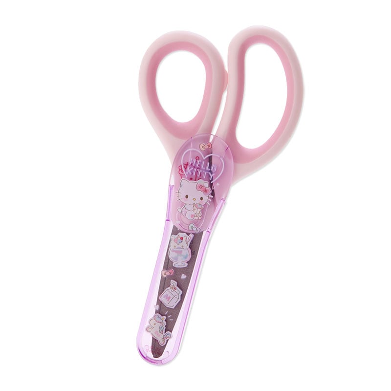 Overhead view of Hello Kitty mini scissors on a craft desk with washi tape.