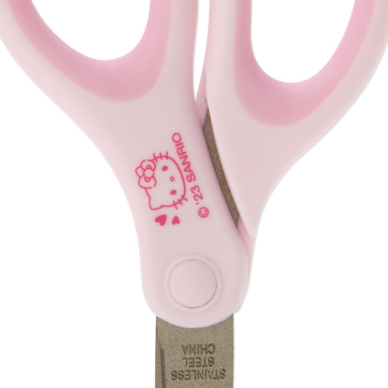 Overhead view of Hello Kitty mini scissors on a craft desk with washi tape.