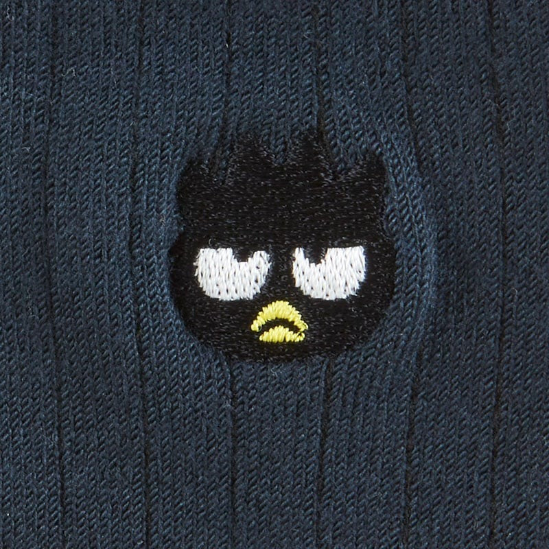Pair of Sanrio socks with Badtz-maru embroidery styled with sneakers