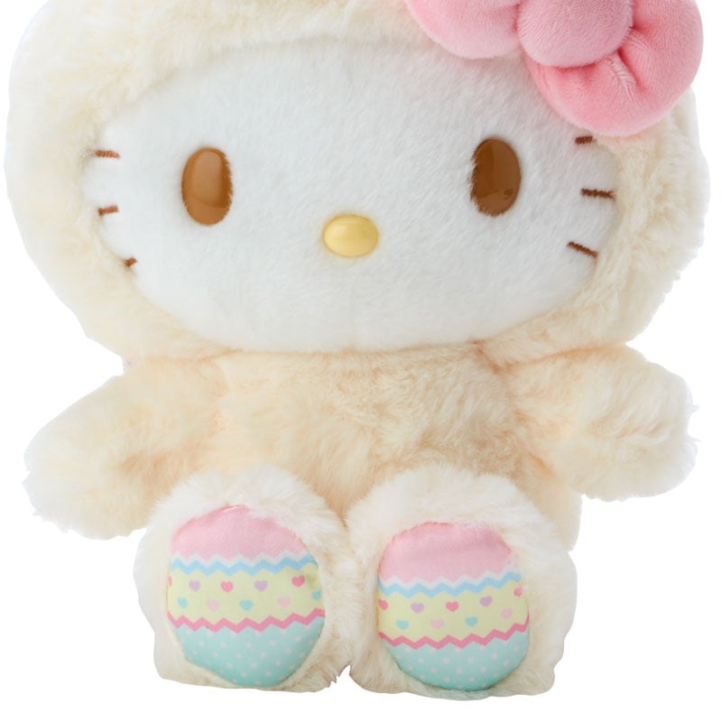 Hello Kitty plush toy in a bunny costume, enjoying a spring-themed setting.