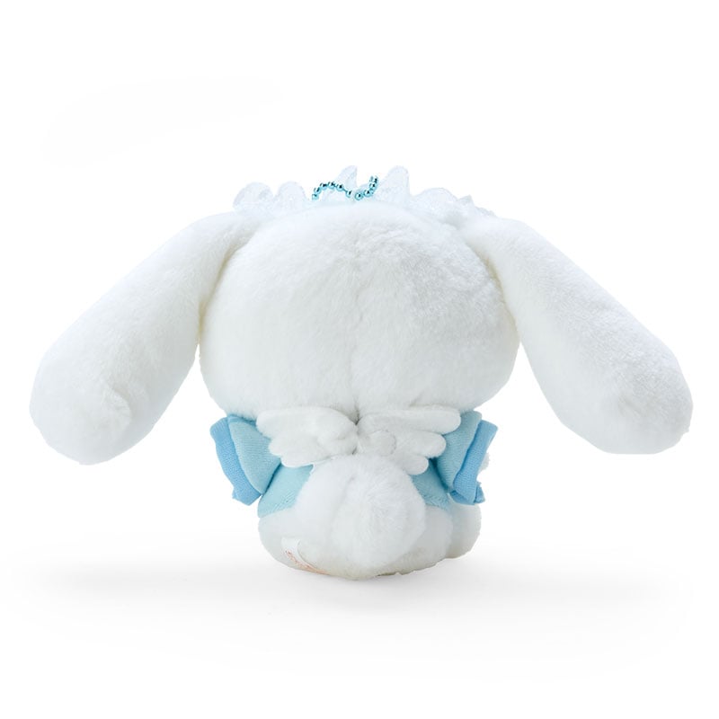 Hand holding Cinnamoroll plush keychain next to keys for size comparison