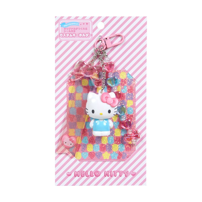 Hello Kitty keychain being customized with alphabet stickers