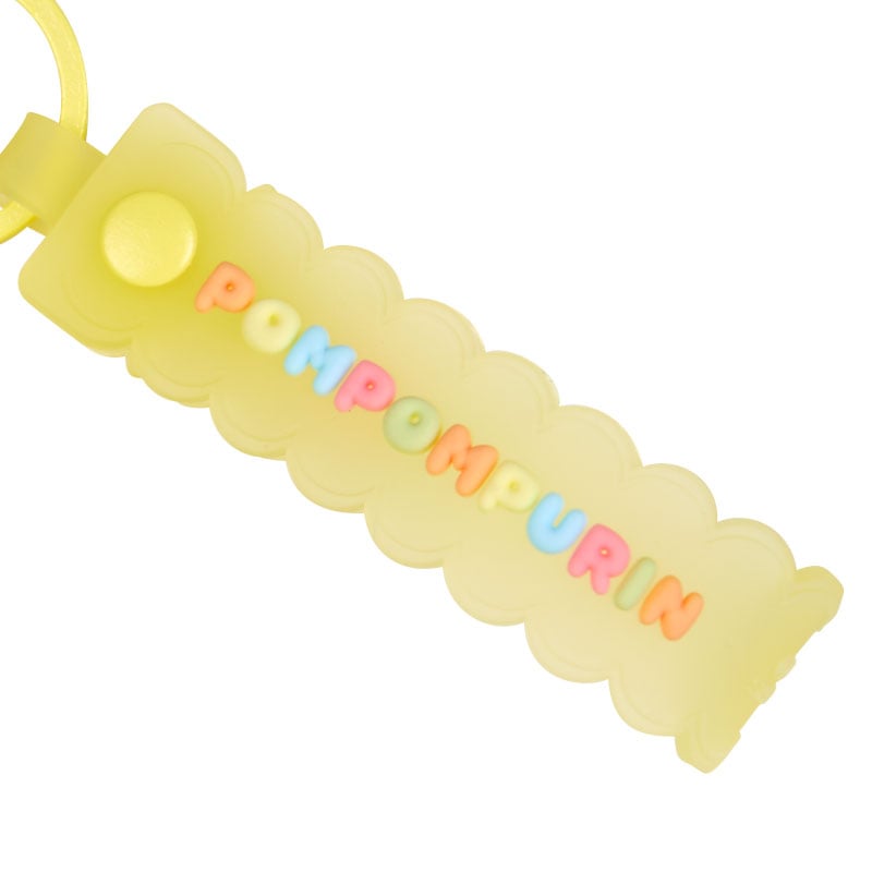 A collection of Sanrio character keychains, including Pompompurin, displayed on a desk.