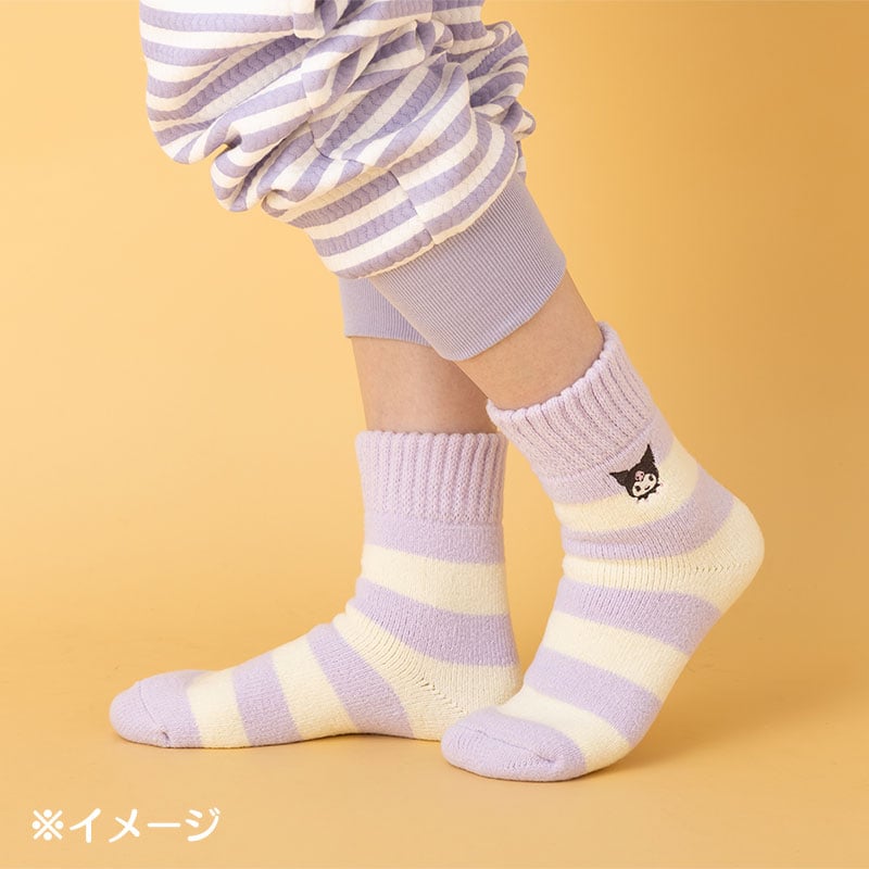 Kuromi striped tube socks styled with loungewear on a couch setting