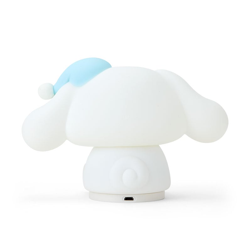 Cinnamoroll squish nightlight lit in low light next to cozy bedding setup