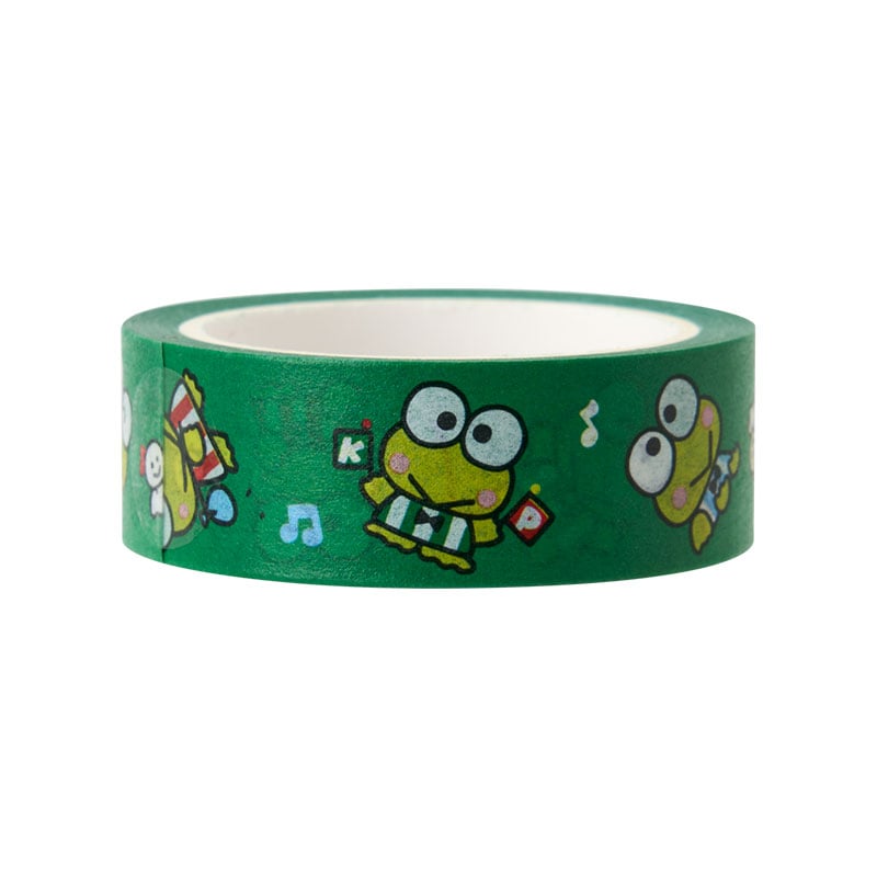 Hand holding Keroppi tape dispenser while decorating a scrapbook page