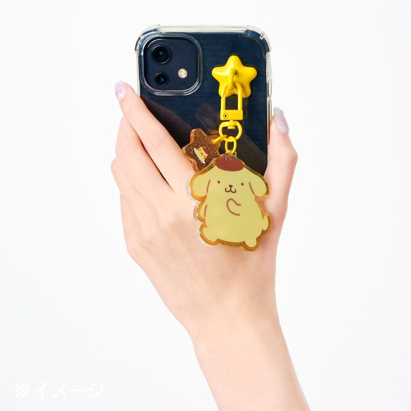 Sanrio Pompompurin charm attached to a phone, with a clip for bag or keychain