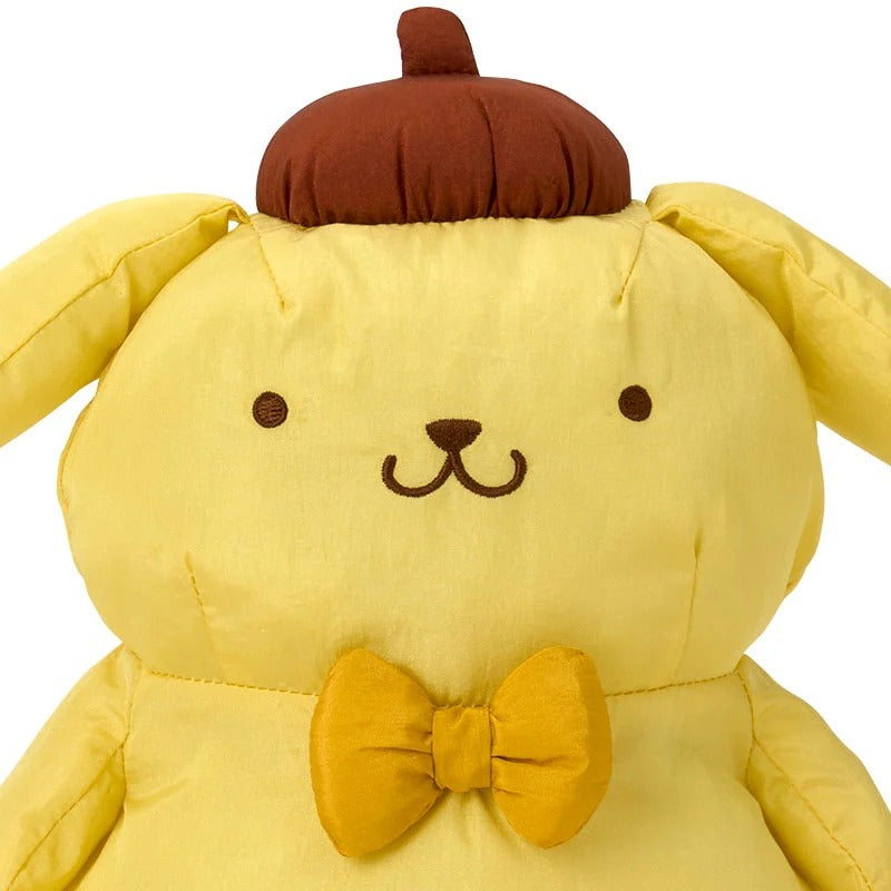 Giant Pompompurin plush sitting on a bed in a childs room